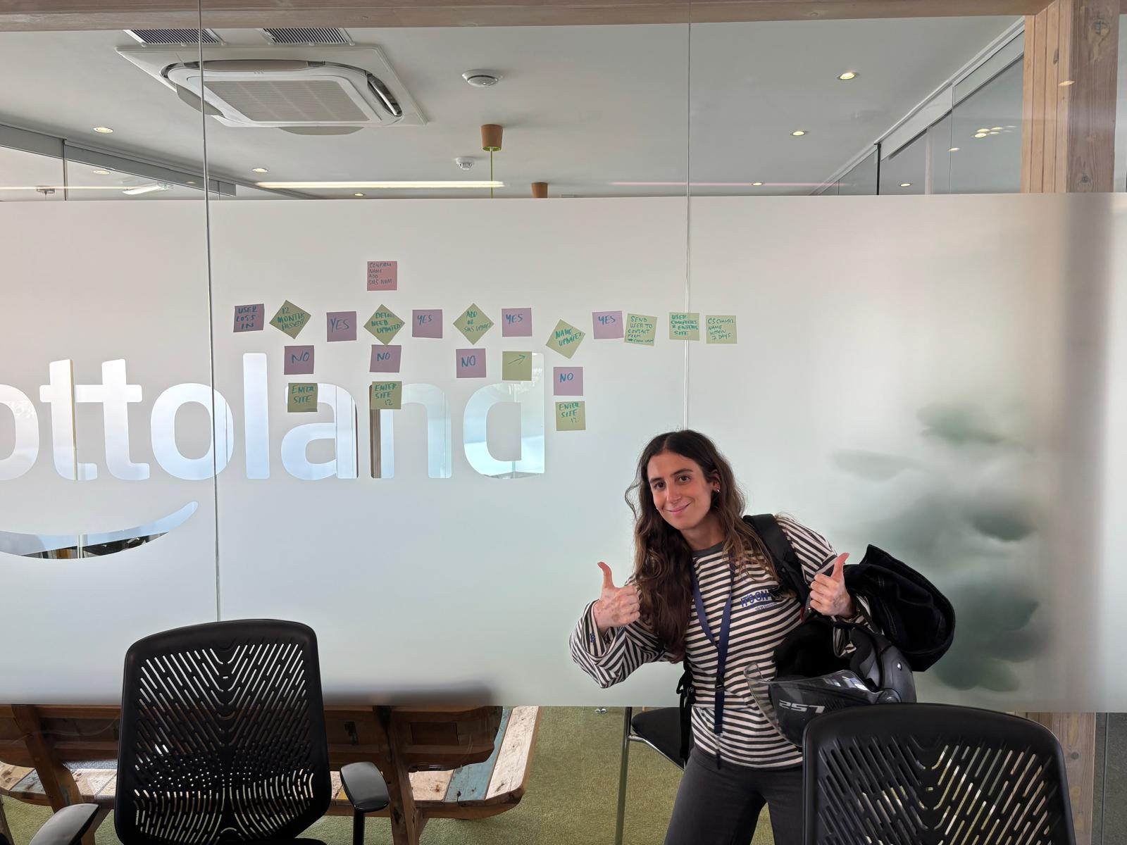 A team member beside a journey and decision flow mapped on a glass wall