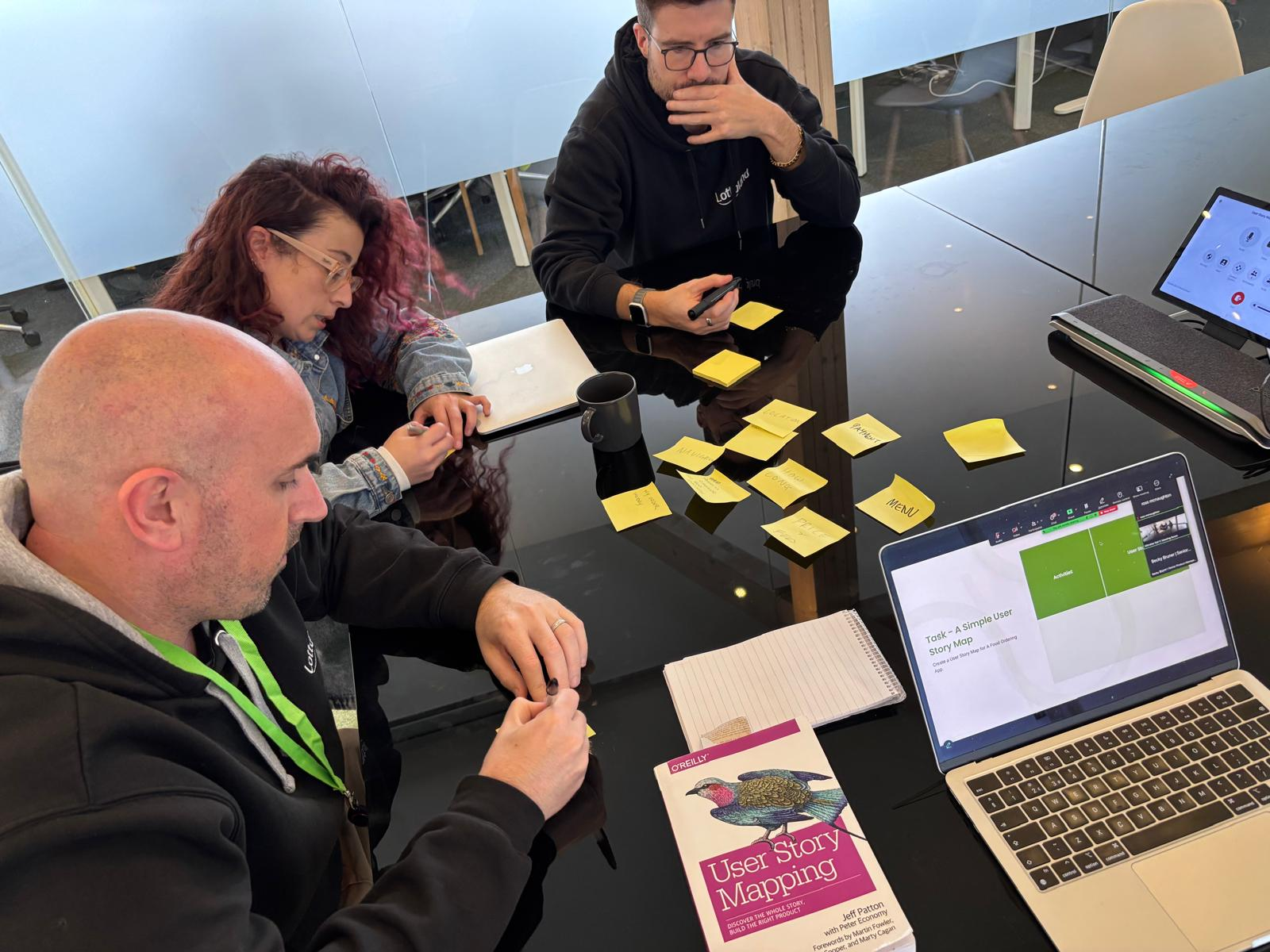 A Lottoland product team working together around a table with sticky notes and user story mapping materials
